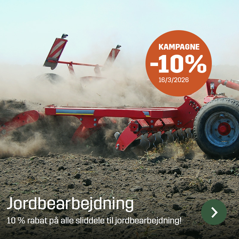 Jordbearbejdningsredskab i arbejde på marken, hvor tallerkener bearbejder jorden og støv hvirvler omkring maskinen. Sagros sliddele til jordbearbejdning bruges til at holde harver og kultivatorer i drift i sæsonen.